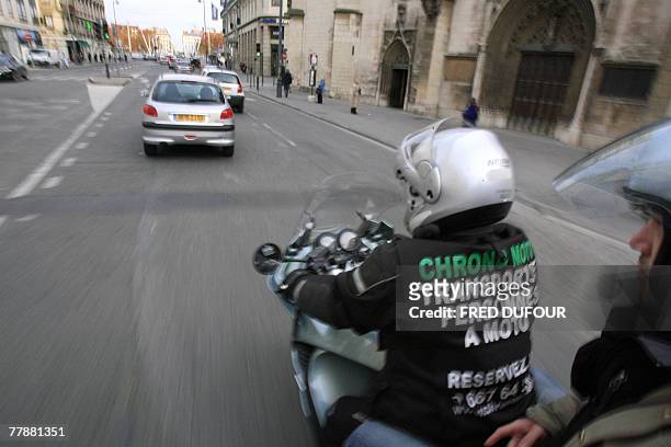 Une personne est tranport?e par un motard de "Chrono-Moto", une entreprise lyonnaise qui propose depuis trois ans un nouveau service de motos-taxis...