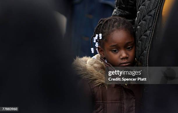 Girls stands with her mother near the spot where a youth was shot and killed by a policeman November 13, 2007 in Brooklyn, New York. After receiving...