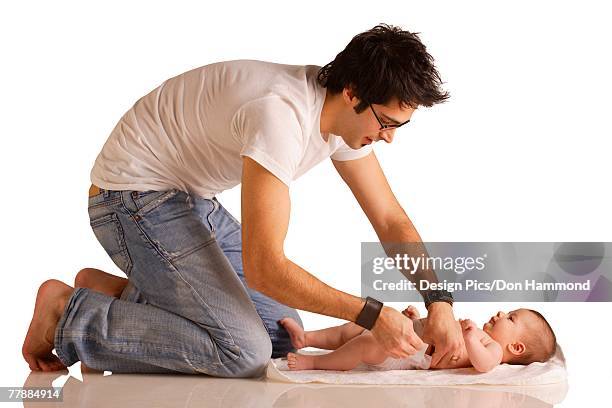 dad changing diaper - nappy change stock pictures, royalty-free photos & images