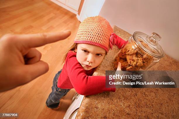 child gets in trouble for sneaking cookies - child cookie jar stockfoto's en -beelden
