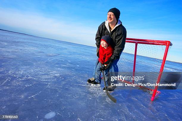 dad and son playing goalie - edmonton winter stock pictures, royalty-free photos & images