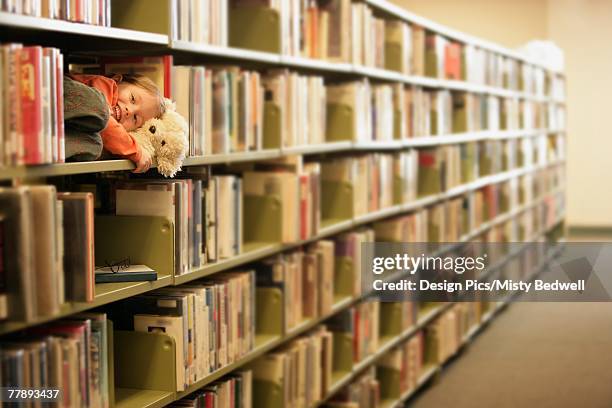 little girl hiding in library - edmonton library stock pictures, royalty-free photos & images