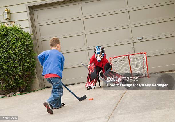 young goalie anticipating a shot on net - hockey puck stock pictures, royalty-free photos & images