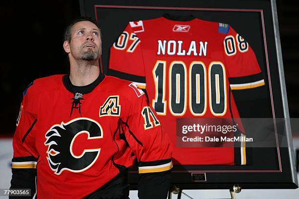 Owen Nolan of the Calgary Flames receives a commemorative jersey for his 1000th game played prior to the NHL game against the San Jose Sharks at the...