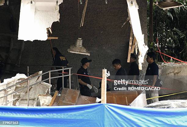 Police explosive experts investigate the sealed bomb blast site at the House of Representatives in Manila 14 November 2007 following a bomb attack...