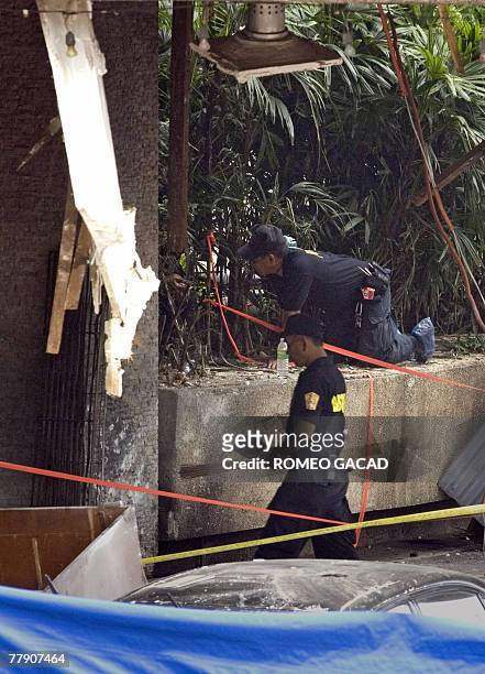Philippine police explosive experts search for evidence at the sealed bomb blast site at the House of Representatives in Manila, 14 November 2007,...