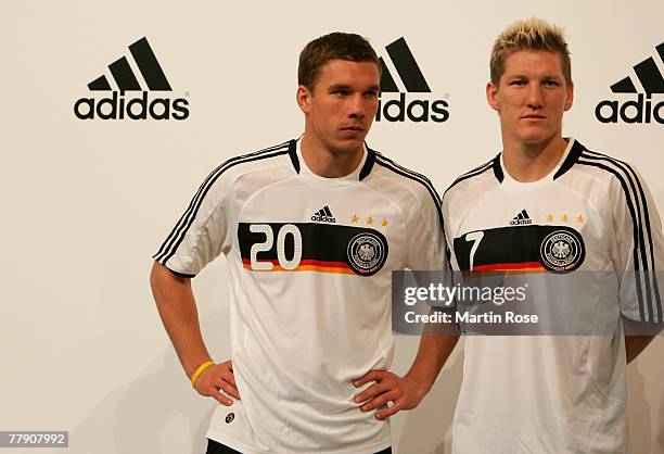 Lukas Podolski and Bastian Schweinsteiger of the German national football team pose for a photocall during a presentation of the Euro2008 Shirt at...