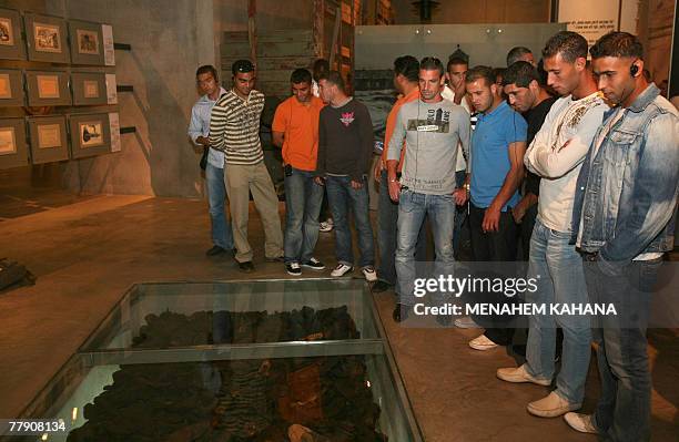 Members of Israeli Arab Bnei Sakhnin and Jewish Kiryat Shmona football team players look at hundreds of shoes belonging to Jews who perished at the...