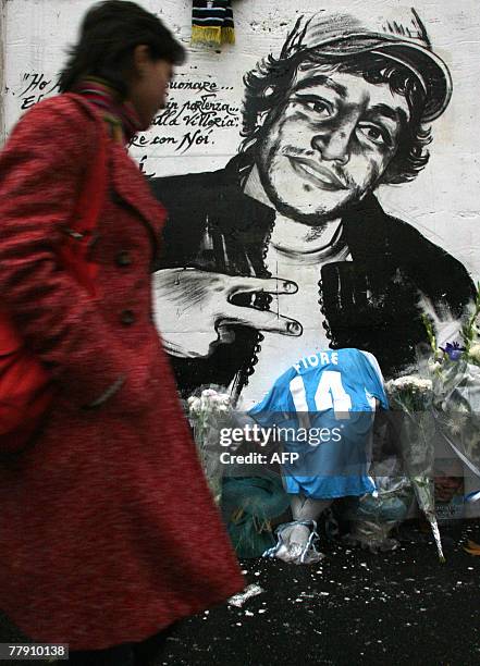 Young woman walks past a mural depicting Gabriele Sandri at the Vescovio Place in dowtown Rome, 14 November 2007. Sandri, a Lazio fan, was shot in...