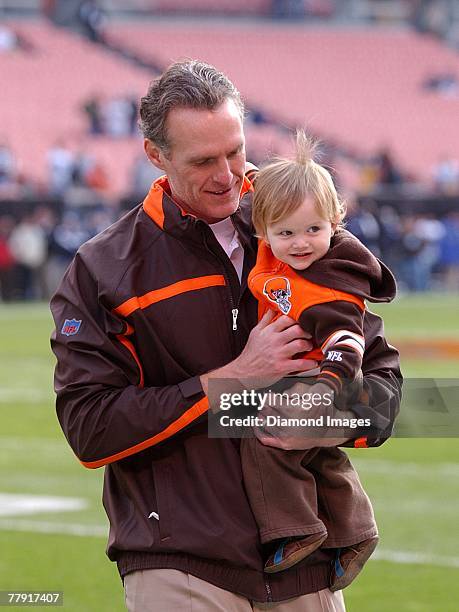 Assistant coach Mike Sullivan of the Cleveland Browns carries his son Patrick off the field prior to a game with the Seattle Seahawks on November 4,...