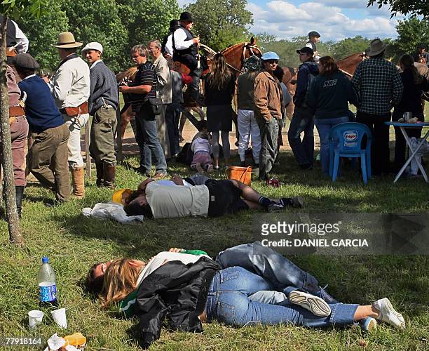 Two couples take a nap during the gaucho's skill competition during the Tradition Day, in San Antonio de Areco, 110 km from Buenos Aires, 11 November...