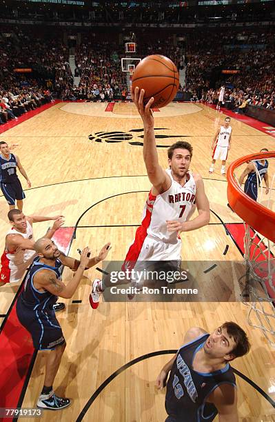 Andrea Bargnani of the Toronto Raptors takes in front of Carlos Boozer and Mehmet Okur of the Utah Jazz on November 14, 2007 at the Air Canada Centre...