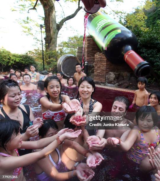 Sommelier pours a bottle of Beaujolais Nouveau into an open air wine spa at the Hakone Kowakien Yunessun on November 15, 2007 in Hakone, Kanagawa...
