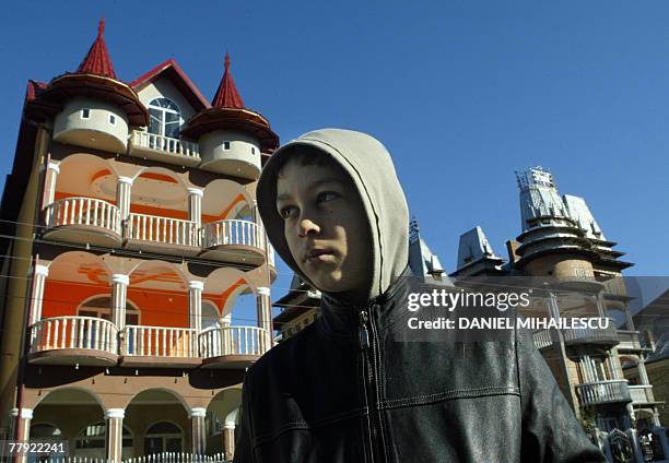 Boy walks in front of Roma gypsy houses in the village of Buzescu, 110 kms west of Bucharest, 13 November 2007. Unlike other residents of Buzescu,...