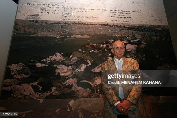 Russian poet, novelist and literature professor, Yevgeny Yevtushenko, stands next to his poem 'Babi Yar' written on a holocaust photo during his...