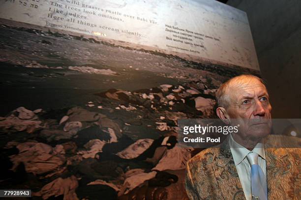 Yevgeny Yevtushenko a Russian poet, novelist and literature professor stands next to his poem 'Babi Yar' written on a holocaust photo during his...