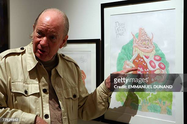 Artist Gahan Wilson points at one of his works "Hansel and Gretel Triptych" on display at an exhibition by New Yorker magazine artists inspired by...