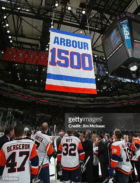 Former head coach Al Arbour of the New York Islanders watches a banner rise to the rafters honoring his 1,500th game coached with the team after...