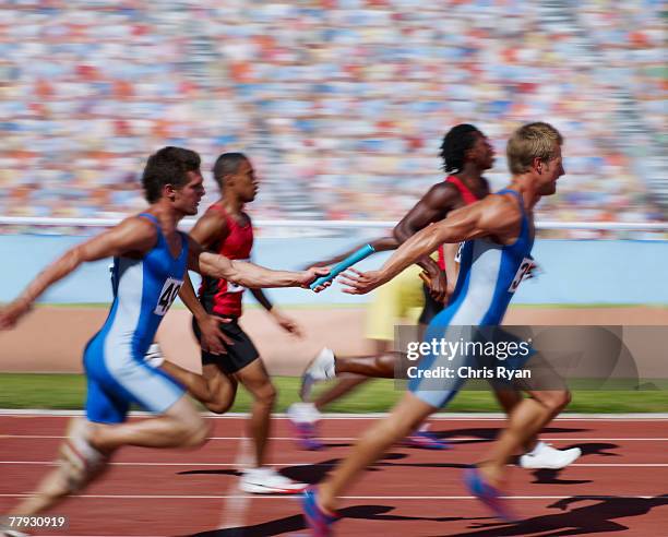 racers running on track with relay baton - teamevenement stockfoto's en -beelden