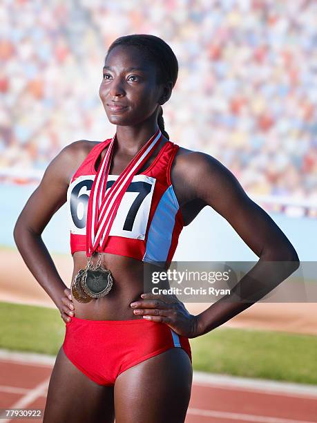 athlete standing proudly with three medals around neck - three quarter length stock pictures, royalty-free photos & images