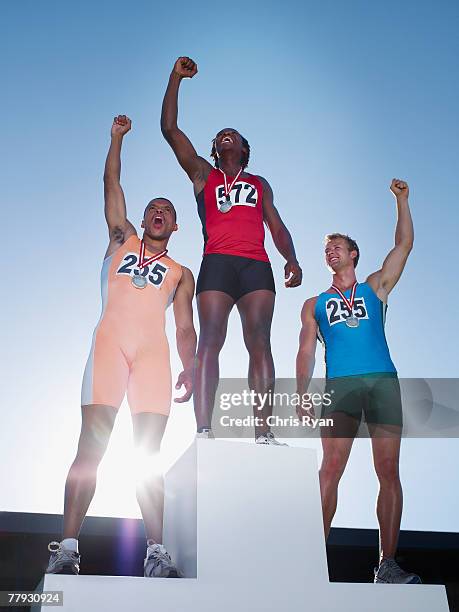 podium with three winning athletes cheering on it - championship day three bildbanksfoton och bilder