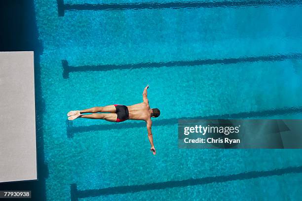 diver midair going into pool - diving sport stock pictures, royalty-free photos & images