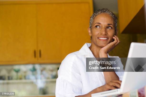 woman sitting at laptop smiling - low angle view laptop stock pictures, royalty-free photos & images