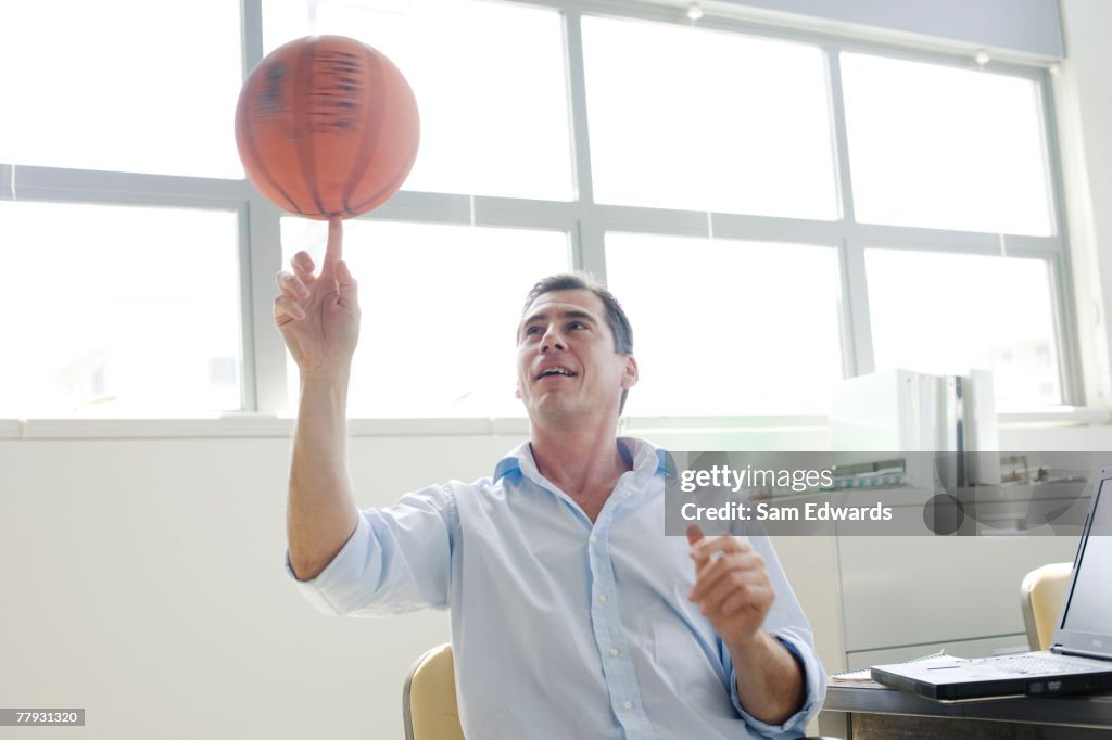 Empresário girar uma Bola de Basquete no dedo no escritório