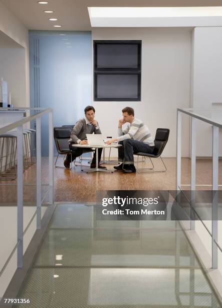 two businessmen looking at a laptop in an office - lobby screen stock pictures, royalty-free photos & images