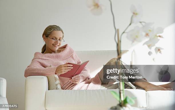 woman reading by a flower - coffee table books stockfoto's en -beelden