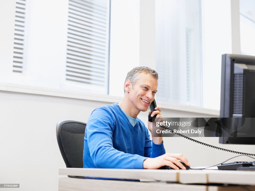 Geschäftsmann am Telefon an seinem computer im Büro