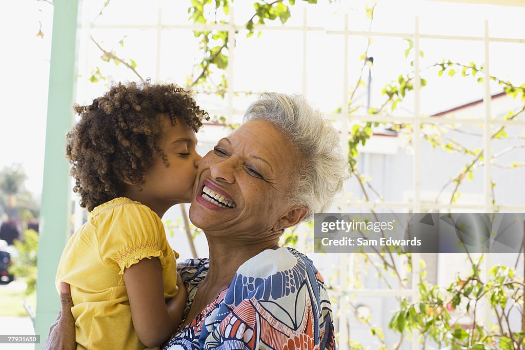 Woman and young girl embracing outdoors