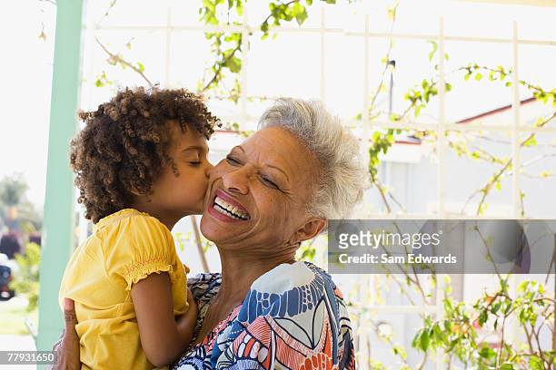 woman and young girl embracing outdoors - granddaughter stock pictures, royalty-free photos & images