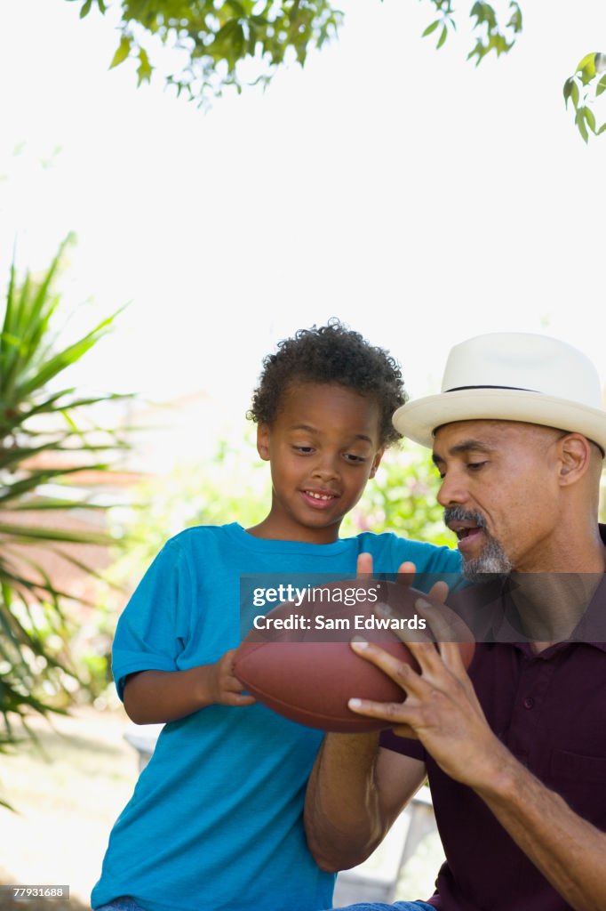 Man and young boy holding football