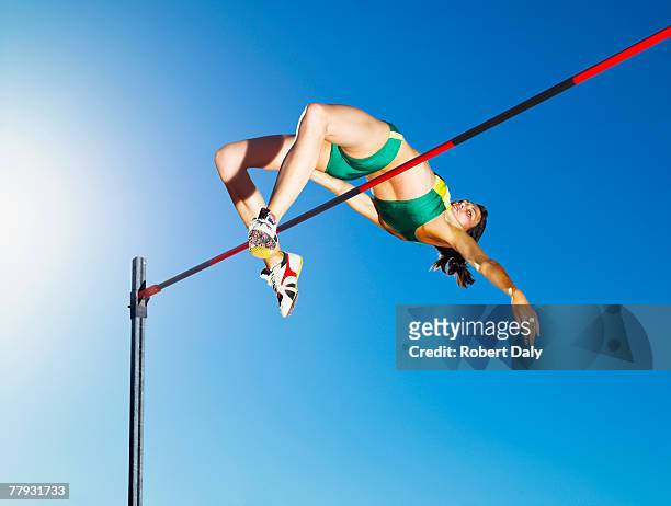 sportler high-jumping in der arena - leichtathletik stock-fotos und bilder