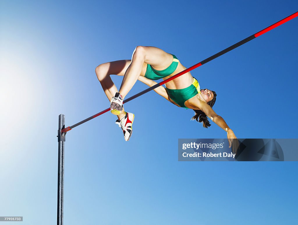 Athlete high jumping in an arena