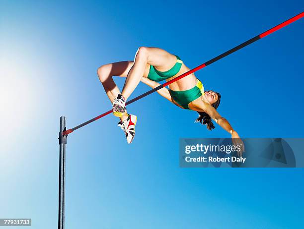 athlete high jumping in an arena - womens high jump stock pictures, royalty-free photos & images