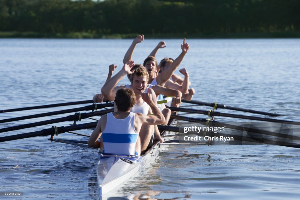 Athletes in a crew row boat cheering