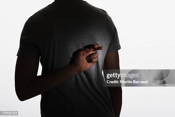 man standing with fingers crossed behind back - fingers crossed stock pictures, royalty-free photos & images