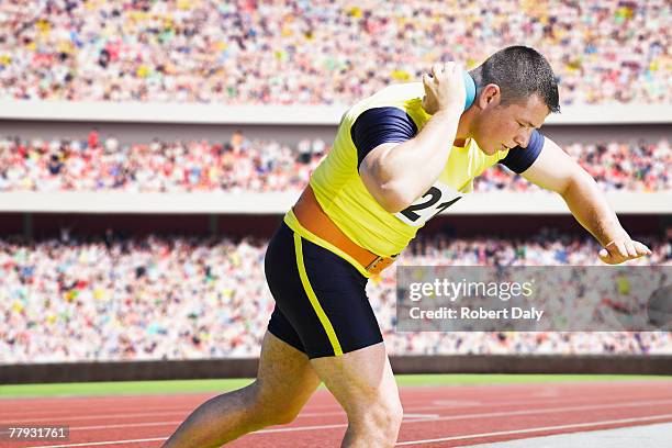 athlete shotputting in an arena - shot put stock pictures, royalty-free photos & images