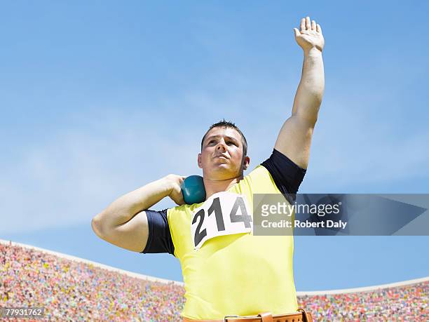 athlete shotputting in an arena - shot put stock pictures, royalty-free photos & images
