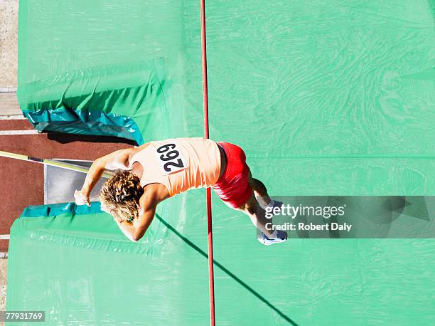 sportler tun stabhochsprung über einen großen passepartout - mens pole vault stock-fotos und bilder