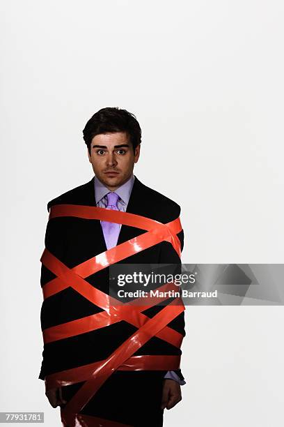 businessman with duct tape around him - administrative professional stock pictures, royalty-free photos & images