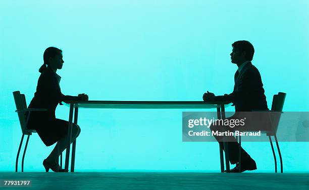 businessman and businesswoman at a table - clashes stock pictures, royalty-free photos & images