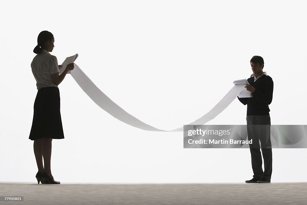 Woman and man looking at both ends of a long document