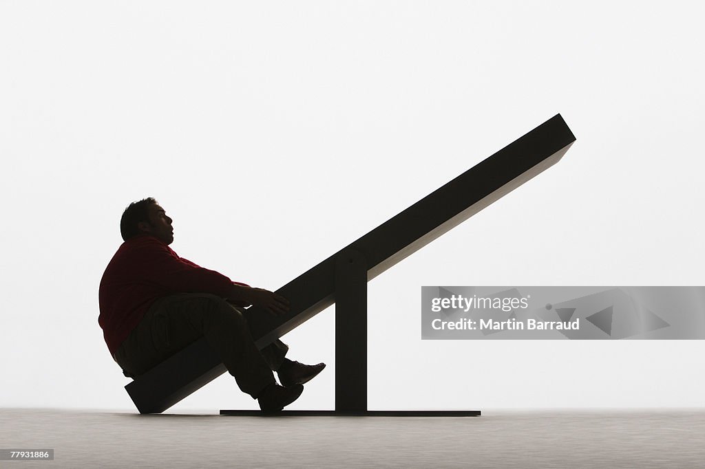 Large man on unbalanced plank