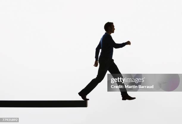 man on a plank about to walk over ledge - man walking silhouette stock pictures, royalty-free photos & images