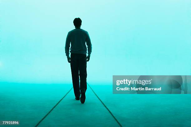 man walking away - tegenlicht stockfoto's en -beelden