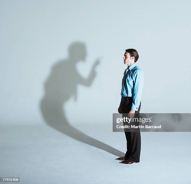 homem sendo scolded com a sua sombra - acusação imagens e fotografias de stock