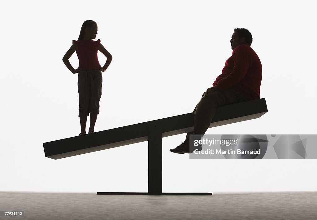 Large man and small girl on unbalanced plank